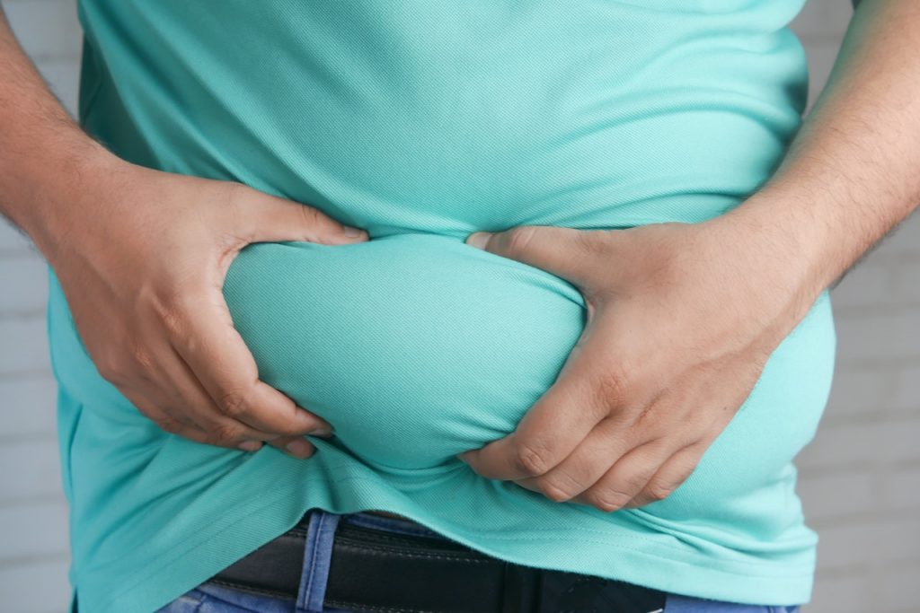 Man squeezing his belly fat